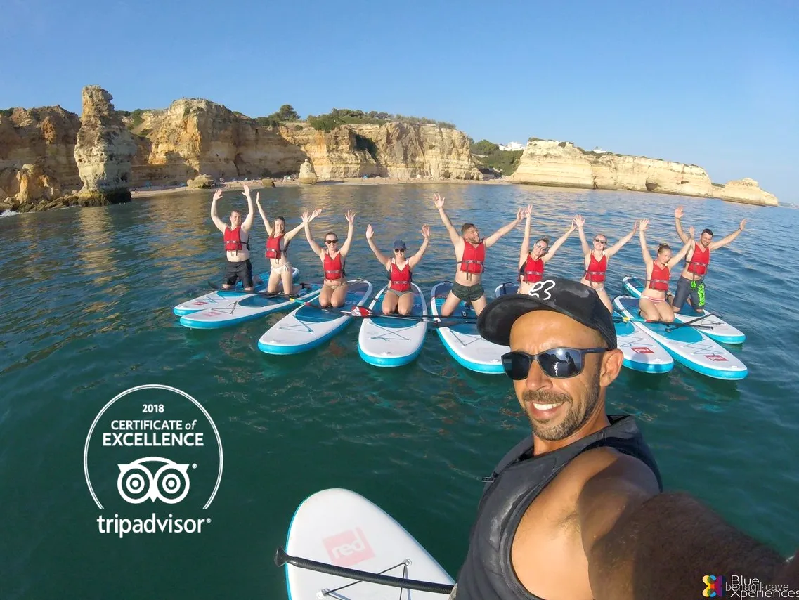 Grupo de stand up paddle dentro de uma gruta marinha perto de Benagil no tour guiado